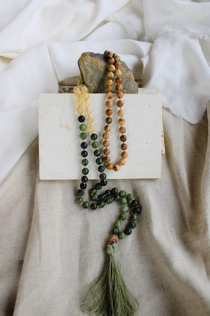 Artistic shot of handmade beaded necklaces on a fabric backdrop showcasing intricate design.